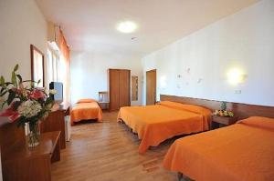 佩鲁贾Hotel Astor的酒店客房带两张带橙色床单的床