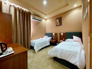 QurţahDahreez motel的酒店客房配有两张床和一张书桌