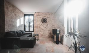 塞尔纳克Mazet en pierre avec jardin privatif的带沙发和砖墙的客厅