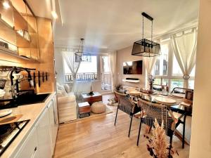 班斯科Boutique lux design apartment @Bansko Royal Towers的厨房以及带桌椅的起居室。