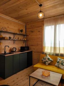 巴统Limoncello的一间带黄色沙发的客厅和一间厨房