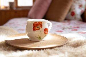 博维茨Bezgova Hišica的咖啡杯坐在床上的盘子上