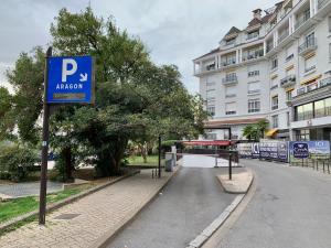 波城Quartier du château, superbe appartement avec parking的建筑旁街道上的蓝色停车标志
