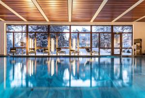 弗利姆斯Romantik Hotel Schweizerhof & Spa的一座带大窗户的房屋内的游泳池