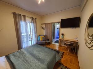 雅典Cozy Little Home的一间卧室配有一张床、一张书桌和一台电视