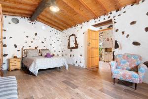 因赫尼奥Casa Las Toscas的一间卧室配有一张床和一把椅子
