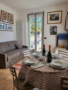 特雷梅佐Residence Belvedere Apartment Volesio的客厅配有带盘子和酒杯的桌子
