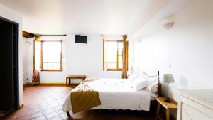 穆斯捷-圣玛丽巴斯蒂德帕拉东酒店的一间白色卧室,配有床和2个窗户