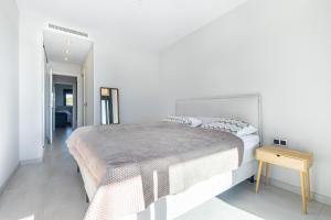贝尼多姆Sunset Waves 3-194 Poniente Beach Resort的白色卧室配有一张大床和一张桌子