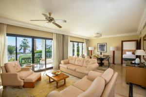 沙姆沙伊赫Park Regency Sharm El Sheikh Resort的带沙发的客厅和带卧室的房间