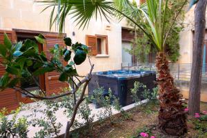 MġarrGetawayNpetto Private Duplex Maisonette with Jacuzzi Hot Tub的花园内的棕榈树和热水浴池