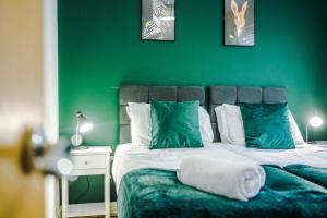 曼彻斯特Lovely 3 Bed house - Park Lane的绿色卧室,配有一张带绿色墙壁的床