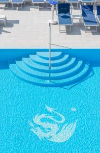 布雷佐内加尔达Hotel Drago - Garda Lake Collection的一个带蓝色椅子的游泳池,一个水中涂有海豚