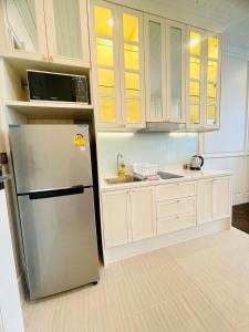 纳仲天Grand Florida Pattaya By TheBest Management的厨房配有不锈钢冰箱和白色橱柜