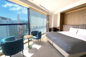 札幌THE KNOT SAPPORO的酒店客房设有一张床和一个大窗户