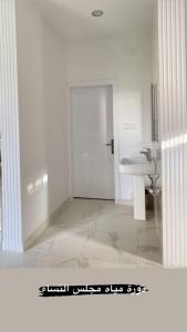 As Sayl aş Şaghīrاستراحة ابن وصيص للمناسبات的白色的浴室设有水槽和门