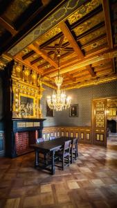 布鲁日Castle ten Berghe Château的一间带桌椅和吊灯的用餐室