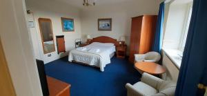 巴罗弗内斯Clarkes Hotel Barrow in Furness的酒店客房带一张床、一张桌子和椅子