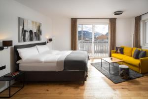 巴德加斯坦Auhof - Apartments Bad Gastein的一间卧室配有一张床和一张黄色的沙发