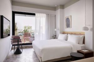 雅典The Social Athens Hotel, a member of Radisson Individuals的酒店客房设有一张白色大床和一个窗户。