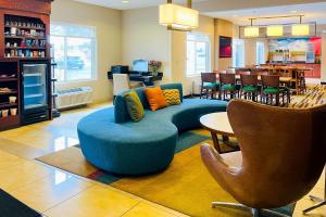 奥拉西Comfort Inn & Suites Olathe - Kansas City的客厅配有蓝色的沙发和椅子