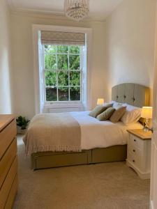 利明顿温泉Regency Apartment的一间卧室设有一张大床和一个窗户。