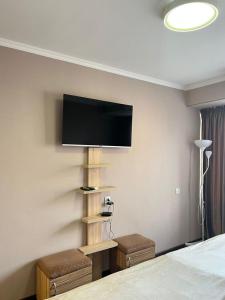 比什凯克Seven Hotel Bishkek的卧室配有一张床和壁挂式平面电视。