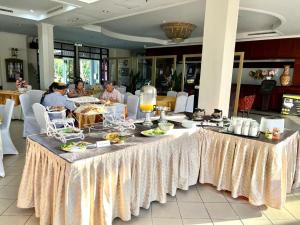Kampung GurunTHE CLOVE MONT HOTEL的餐厅里一张长桌,上面有食物