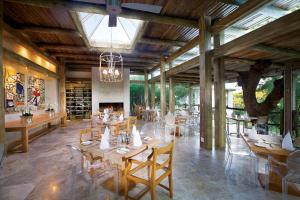 卡帕玛私人野生动物保护区卡帕玛卡鲁拉山林小屋的餐厅设有木桌、椅子和壁炉