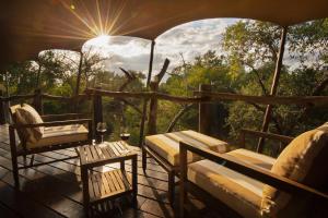 卡帕玛私人野生动物保护区卡帕玛布法罗营豪华帐篷的门廊配有桌椅,享有阳光