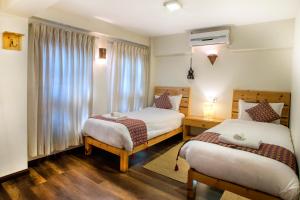 帕坦Hotel Timila的酒店客房设有两张床和窗户。