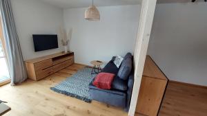 罗孚尔Ferienwohnung Ida的客厅配有蓝色的沙发和电视