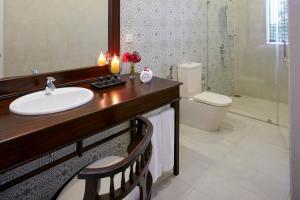 波隆纳鲁沃艾科湖屋酒店的一间带水槽、卫生间和镜子的浴室