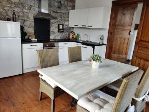 希迈Appartement cosy à Chimay的厨房配有桌椅和白色冰箱。