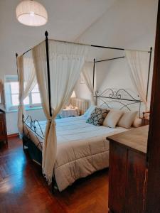 卢卡Lucca sui tetti的一间卧室配有一张带天蓬的大床