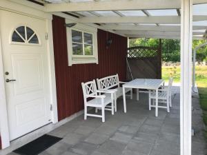 VittarydB & B Flattinge Fritidshus的一个带桌椅的庭院和一扇白色门