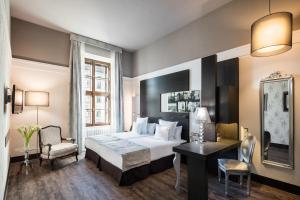 布尔诺巴瑟罗布尔诺宫殿酒店的配有一张床和一张书桌的酒店客房