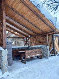 塔塔里夫Voyage Tatariv的雪中带长凳的木亭子