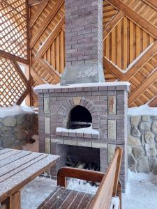 塔塔里夫Voyage Tatariv的室外砖炉,配有桌子和长凳