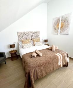 马贝拉Hostal El Caprichito Marbella的一间卧室配有一张大床和毛巾