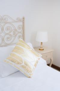 马尔米堡拉皮妮塔马雷酒店的白色的床,上面有黄色和白色的枕头