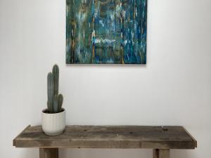 奥格地区伯夫龙La Maison Harmony的仙人掌坐在一张木桌前的画作上