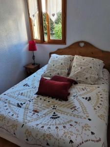日耶Petit cocon entre lac, golf et montagne, proche d'Annecy的卧室配有白色的床和红色枕头