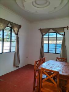 帕杰Mambo Leo Hostel的客房设有桌椅和窗户。