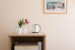 贝尼蔡斯CORFU MARIS BELLOS的一张桌子、咖啡壶和鲜花