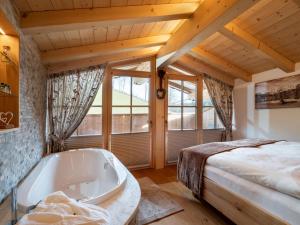 蒂罗尔州奥伯恩多夫Luxusappartement Alpenliebe的卧室配有床和浴缸