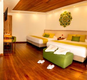 巴尼奥斯桑盖Spa酒店的酒店客房带两张床和一个绿色的箱式凳