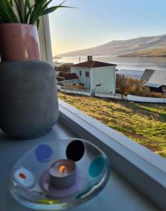 TvøroyriSummarhús29的窗户边的蜡烛,享有房子的景色