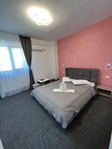 康斯坦察Hotel AMA WORLD的一间卧室设有一张大床和粉红色的墙壁