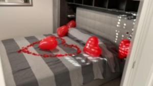 托瓦尼亚La casa di Mare的一张床上有红色的心脏气球的床